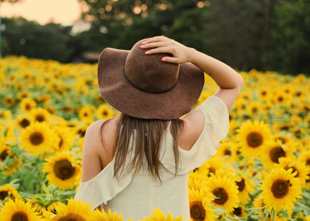 pexels-photo-906002-906002 A woman enjoying the beauty of a sunflower field in summer's golden glow.