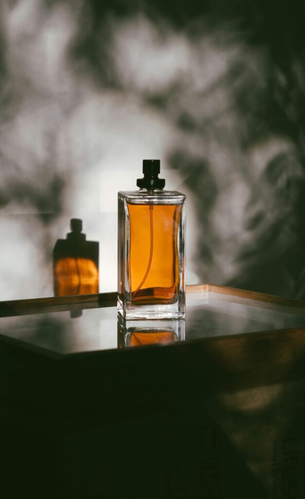 Bottle of perfume in a smoke of fragrance.